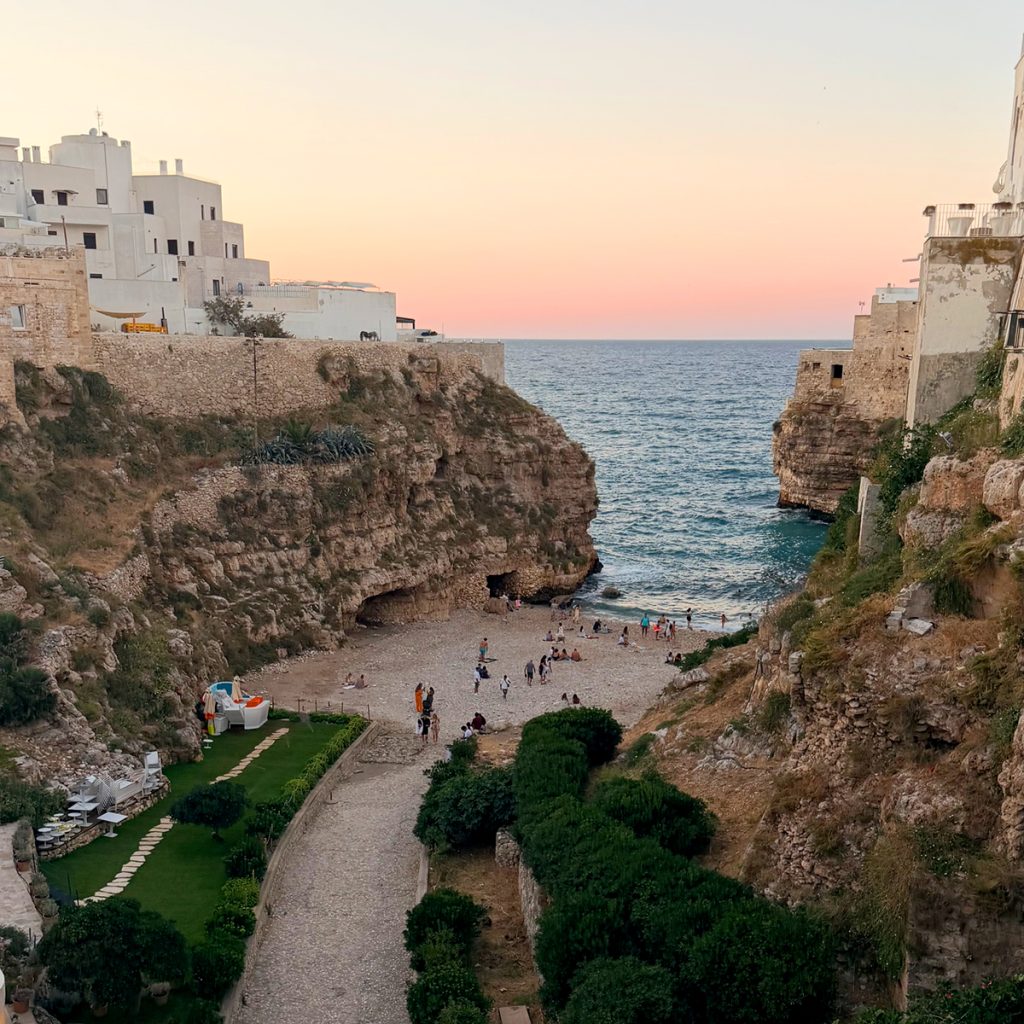 Lama Monachile paplūdimys Polignano a Mare saulėlydžio metu