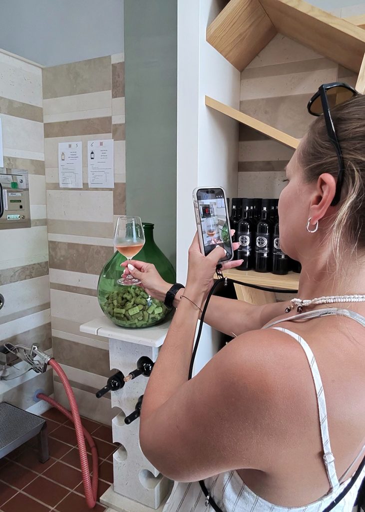 Viešnia fotografuoja vyno ūkio talpų salėje